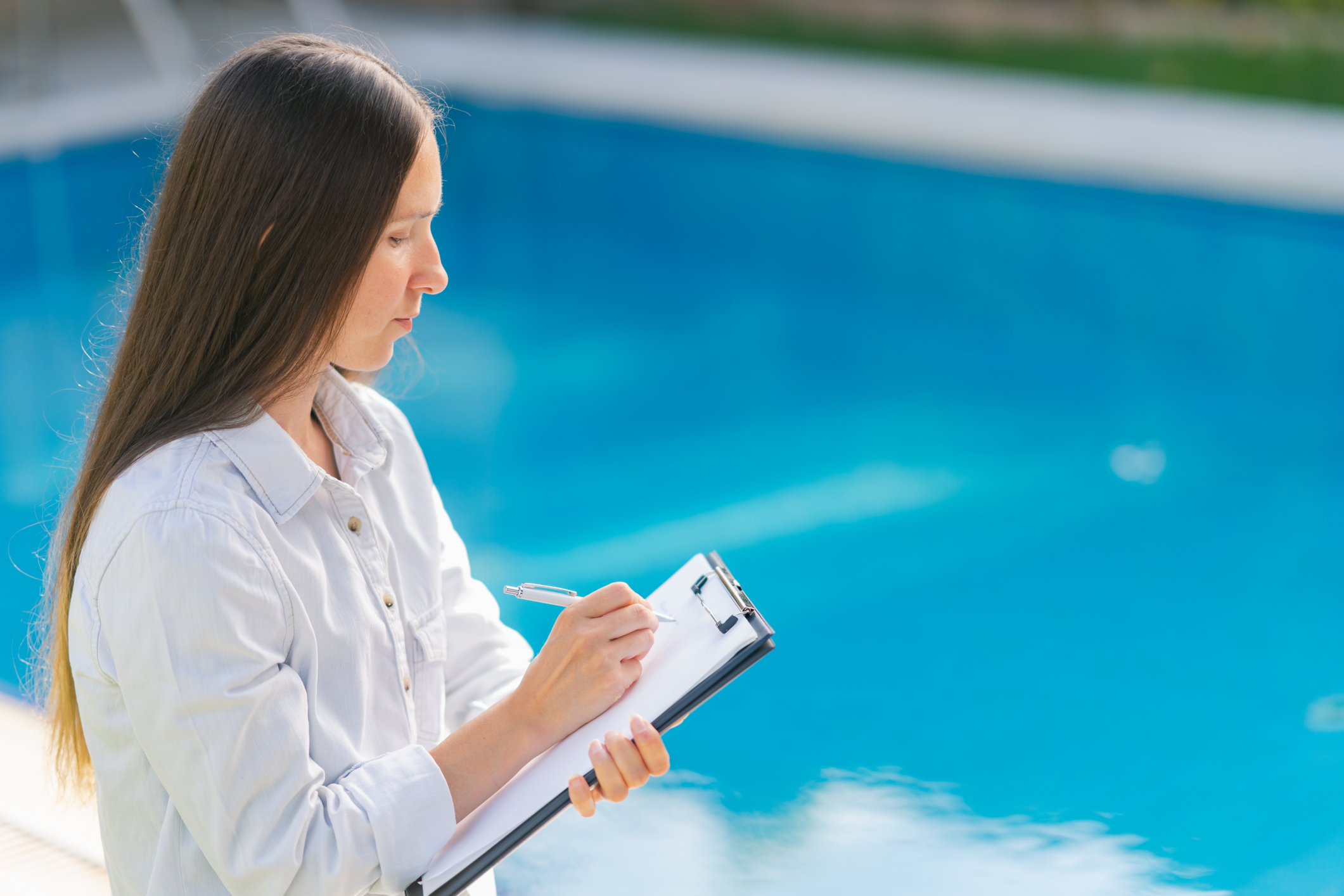 Female worker checking quality of swimming pool