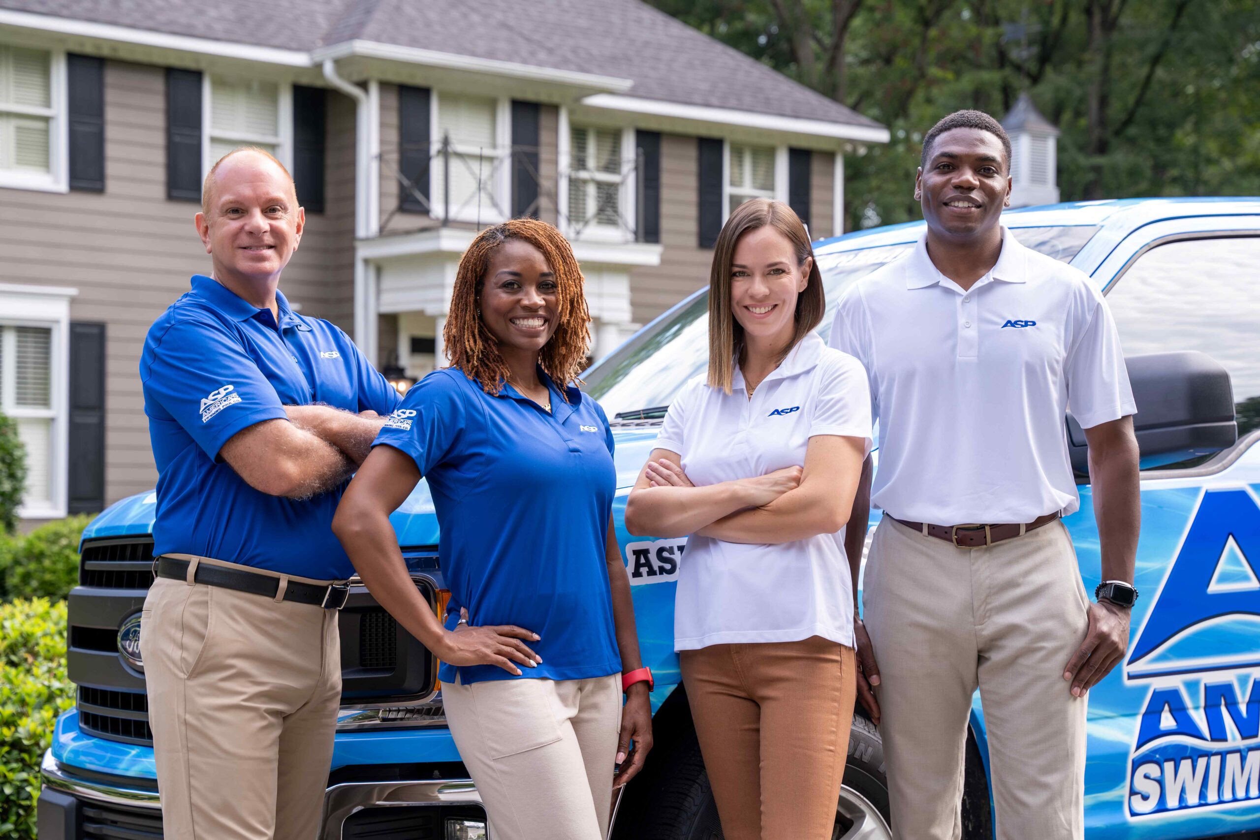 ASP franchise owners standing beside vehicle